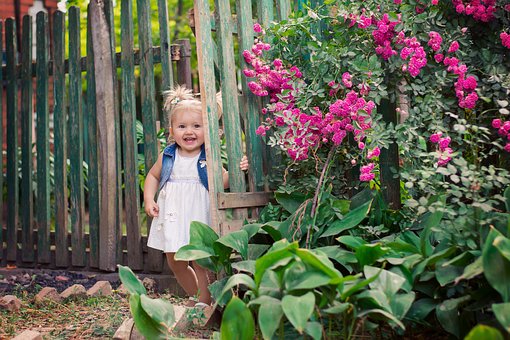 Little girl smiling in back yard because she can enjoy it swat-free!